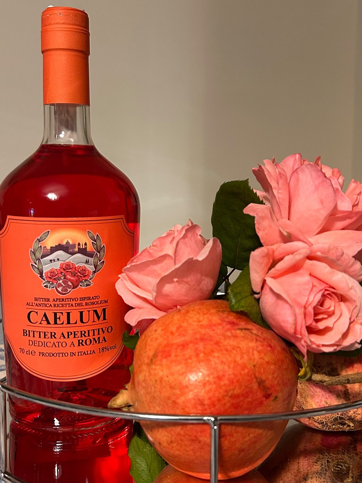 Bottiglia di Bitter Aperitivo Caelum tra rose e melograni